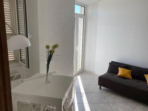 a white living room with a couch and a table at Côté Vieux Port in Bastia
