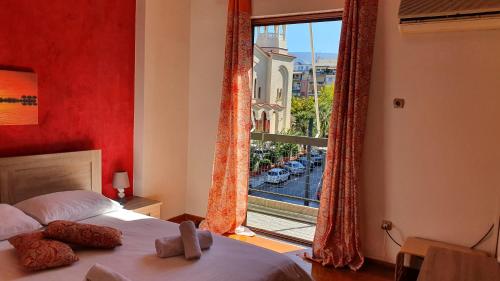 - une chambre avec un lit et une grande fenêtre dans l'établissement Marianas Inn, à Athènes