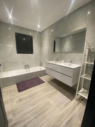 La salle de bains est pourvue de 2 lavabos, d'une baignoire et d'une télévision. dans l'établissement Villa moderne avec piscine Aubenas, à Saint-Étienne-de-Fontbellon