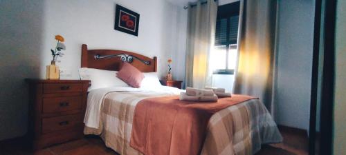 a bedroom with a bed and a dresser with towels on it at Alojamientos Puerta del Parque in Cazorla