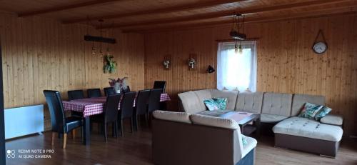 salon z kanapą, stołem i krzesłami w obiekcie Chata z widokiem na Babią Górę w mieście Pewel Wielka