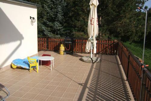 a patio with an umbrella and a table and an umbrella at Penzion V Roklich & Apartmens V Roklich in Ricany
