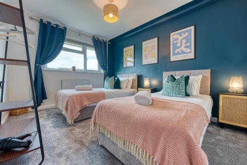 2 camas en una habitación con paredes azules en 3 bedrooms, garden, free parking en Cirencester