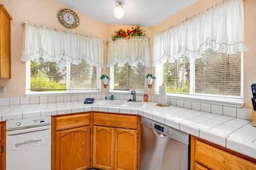 a kitchen with a sink and two windows at Mendocino Dunes - Sandrahla in Fort Bragg