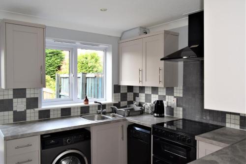 a kitchen with a sink and a dishwasher at Cosy 3 bedroomed home on 3 floors in Darlington