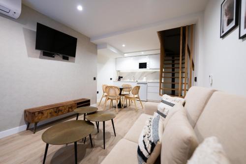 sala de estar con sofá y mesa en Apartamentos Málaga Premium - Calle San Telmo en Málaga