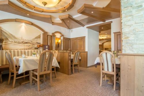 a dining room with tables and chairs and a ceiling at Alphotel Garni Salner in Ischgl