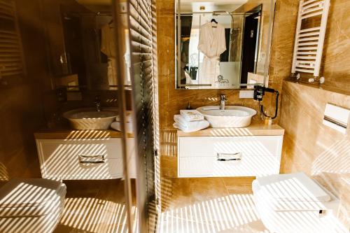 a bathroom with two sinks and a mirror at Lion's Hotel in Chişinău