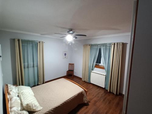 1 dormitorio con 1 cama y ventilador de techo en Casa da rosinha - Minho, Portugal, en Arcos de Valdevez