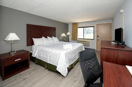 a hotel room with a bed and a flat screen tv at Americas Best Value Inn at Central Valley-Woodbury in Central Valley