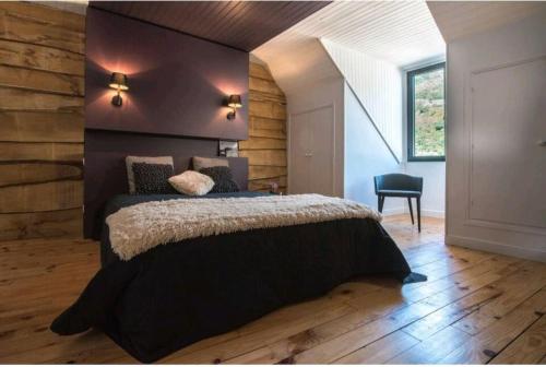 une chambre avec un grand lit avec un plancher en bois dans l'établissement Agréable maison de ville, à Saint-Lary-Soulan