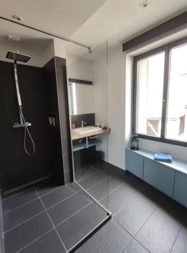 une salle de bain avec une douche en verre et un lavabo dans l'établissement Agréable maison de ville, à Saint-Lary-Soulan
