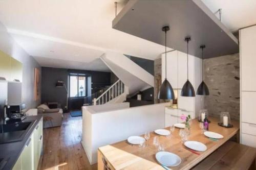 Una cocina y una sala de estar con una mesa de madera con platos encima. en Agréable maison de ville, en Saint-Lary-Soulan