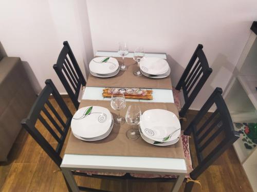 a table with chairs and plates and wine glasses at las llaves del arca in Trujillo
