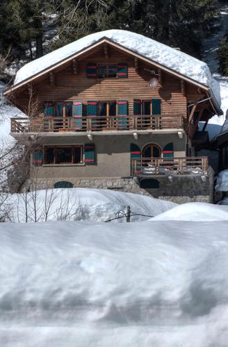 a wooden house with snow on the roof at La Ribambelle in Chamonix-Mont-Blanc