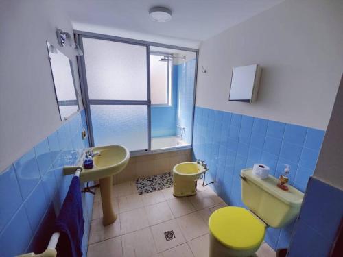 a bathroom with a yellow toilet and a sink at Cómodo, amplio y céntrico apartamento en Sopocachi in La Paz