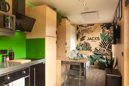 kuchnia ze stołem i zieloną ścianą w obiekcie The Jungle - Unique Cabin in Millport w mieście Millport