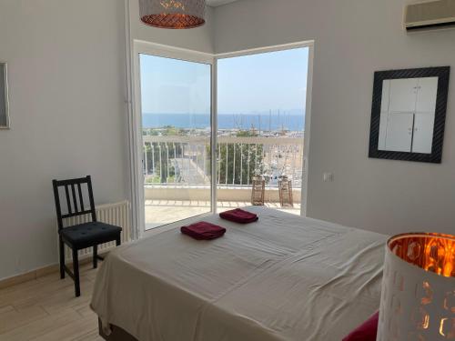 雅典的住宿－Athens Edem Beach Penthouse, panoramic sea view，一间卧室设有一张床和一个大窗户