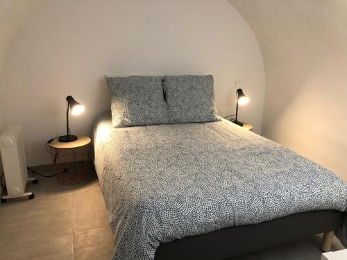 une chambre avec un lit avec deux oreillers dessus dans l'établissement Les Olives Wifi Netflix Appart-hotel-Provence, à La Fare-les-Oliviers