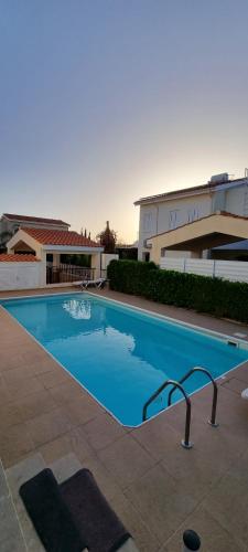 une grande piscine en face d'un bâtiment dans l'établissement Fab Sea and Mountain View Villa, walking distance from the Sandy Beach, à Yialia