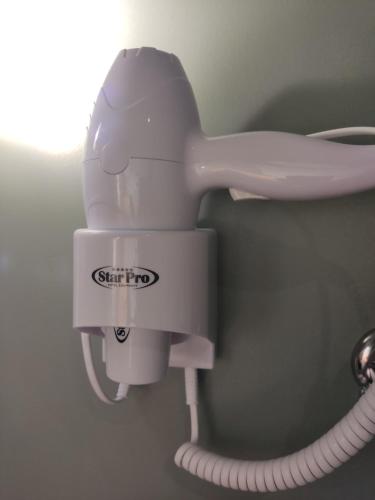 a white hair dryer hanging on a wall at 1920s Rooms in Kalamata