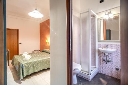 łazienka z łóżkiem i umywalką w pokoju w obiekcie Hotel Millerose w Rzymie
