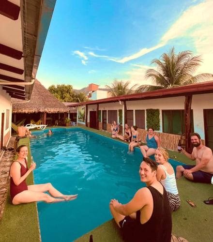a group of people sitting around a swimming pool at El Curichal Hostel in Rurrenabaque