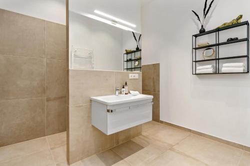 W łazience znajduje się biała umywalka i lustro. w obiekcie Loft-Appartements mit Terrasse w Bremie