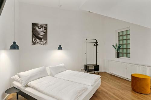 a white room with a white bed and a window at MEL&BENS Loft-Appartements Terrasse Weserstadion in Bremen
