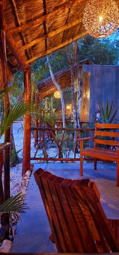 a wooden porch with a bench and a tree at Hotel Kin Tulum Jungle Deluxe in Tulum