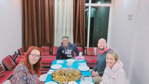 a group of people sitting around a table with a cake at Petra paradise home in Wadi Musa