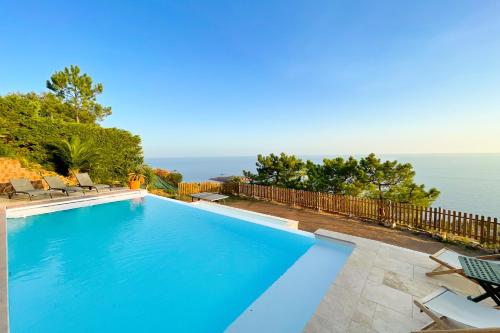a swimming pool with a view of the ocean at Family villa with magnificent sea view for 11 people in Saint-Raphaël