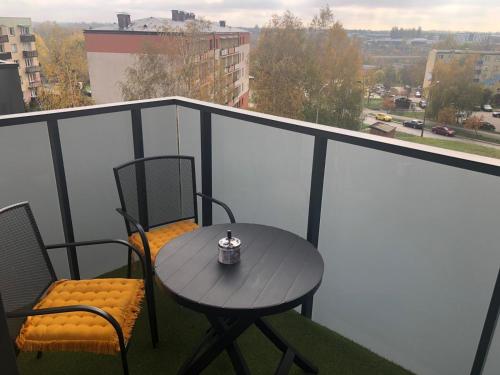 a table and chairs on a balcony with a view at ApartamentySnu, Struga Tower Gold z parkingiem in Radom