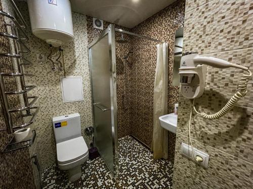 ein Bad mit einer Dusche, einem WC und einem Waschbecken in der Unterkunft Victory - апартаменты возле набережной in Krementschuk
