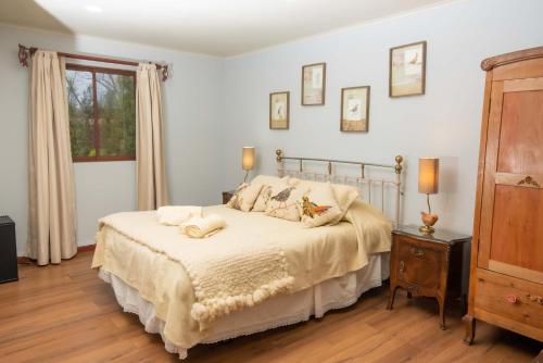 um quarto com uma cama e piso em madeira em Hotel Boutique Raíces de Colchagua em Santa Cruz