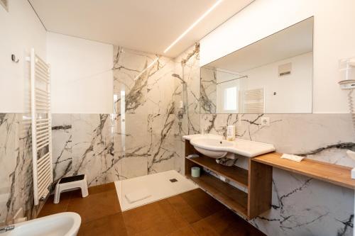 a bathroom with a sink and a mirror at Parkhotel Zur Linde in Silandro