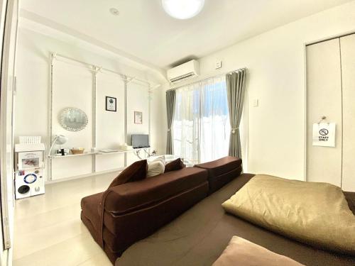 a living room with a couch and a bed at La Lumiere Oroku / Vacation STAY 1043 in Naha