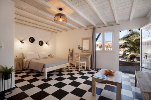 1 dormitorio con 1 cama y suelo blanco y negro a cuadros en Happy Apartments Mykonos, en Klouvas