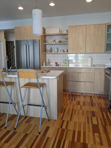 a kitchen with wooden floors and stainless steel appliances at Central location close to Downtown and Mountain Views in South Salt Lake
