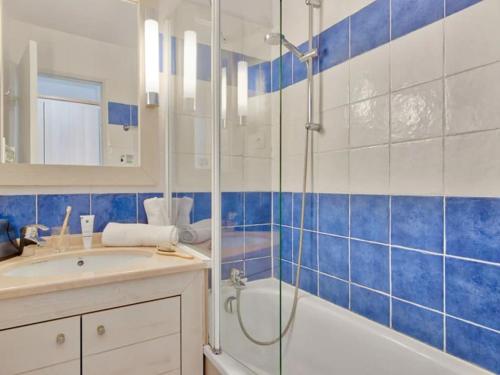 a blue and white bathroom with a shower and a sink at Superbe Appartement à 50 m de la mer in Hyères