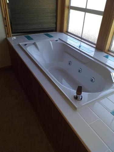 a large bath tub in a bathroom with a window at Rarangi Seaview On the Beach B&B in Blenheim