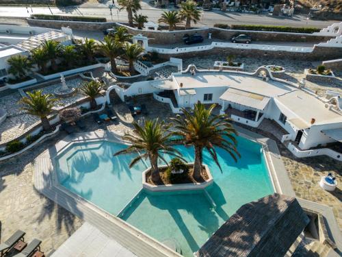 una vista aérea de una piscina del complejo con palmeras en Happy Apartments Mykonos, en Klouvas