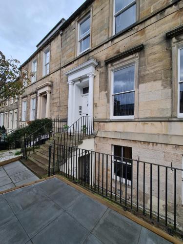 um edifício com uma cerca em frente em Pilrig St Rooms em Edinburgo