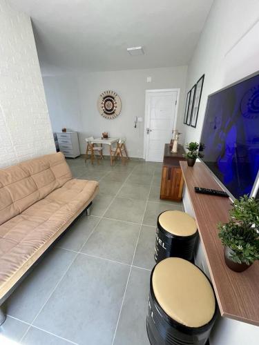 - un salon avec un canapé et deux tabourets dans l'établissement Apartamento Vista Mar - Marina, à Praia Grande