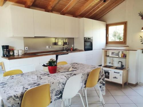 a kitchen with a table and chairs in a kitchen at Confortable chalet avec magnifique vue en Gruyère. in Charmey