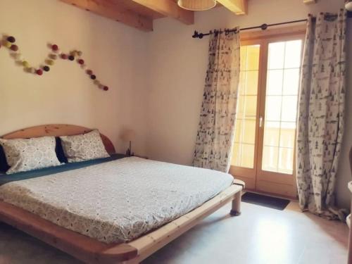 una camera da letto con un letto e una finestra con tende di Confortable chalet avec magnifique vue en Gruyère. a Charmey