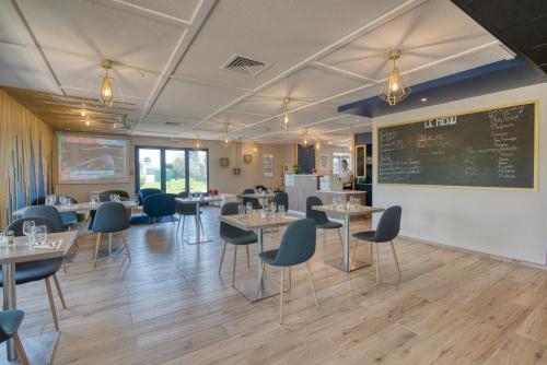 a dining room with tables and chairs and a chalkboard at Kyriad Montauban Sud - Albasud in Montauban