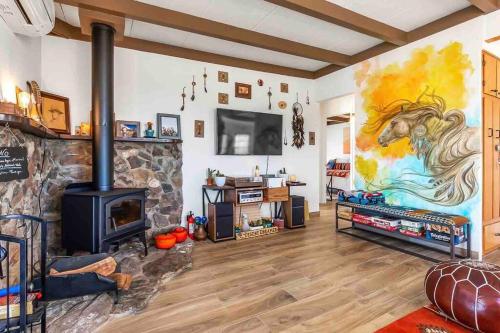 a living room with a fireplace and a painting of a horse on the wall at Desert Dreamer in Yucca Valley