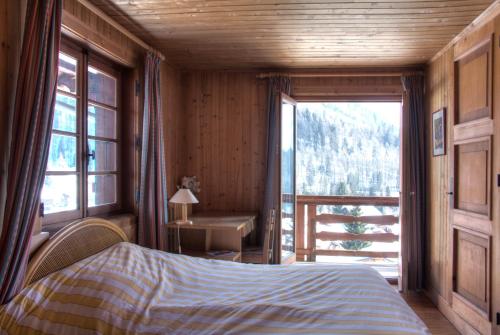 una camera con un letto e una grande finestra di La Ribambelle a Chamonix-Mont-Blanc