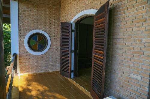 a brick wall with a door and a window at Casa da Cocanha COND com PISCINA-SINUCA-CHURRASQ-DECK com vista para o mar in Caraguatatuba